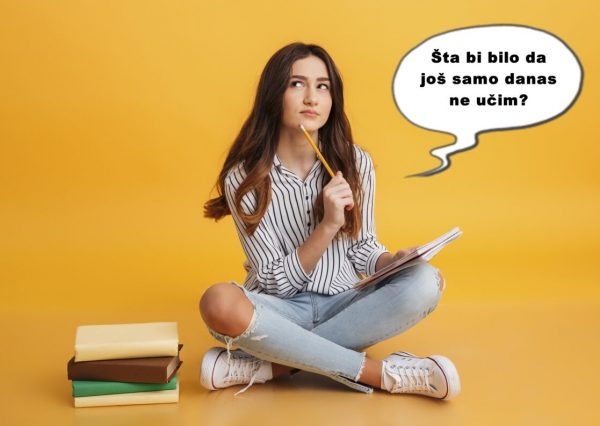 Portrait of a pensive young girl making notes while sitting with books isolated over yellow background